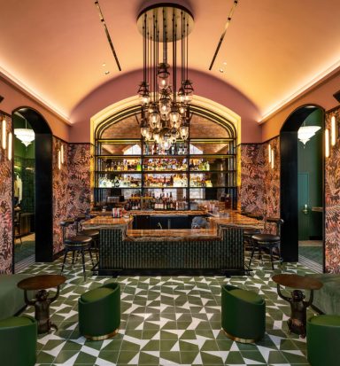 Stylish bar interior with patterned floor, lush seating, and elegant lighting.
