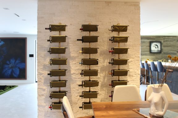 Wine racks mounted on a white brick wall in a modern dining space.