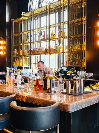 A stylish bar with a bartender, bottles, and a chic, modern interior design.